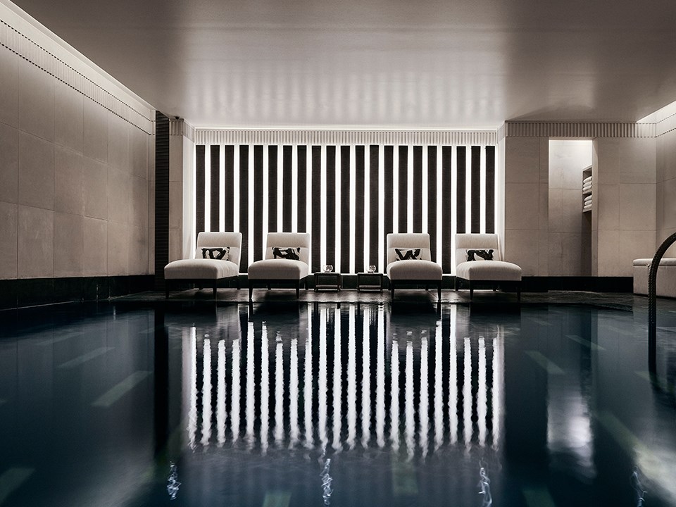 Four comfortable recliners, next to the black granite swimming pool in Aman Spa.