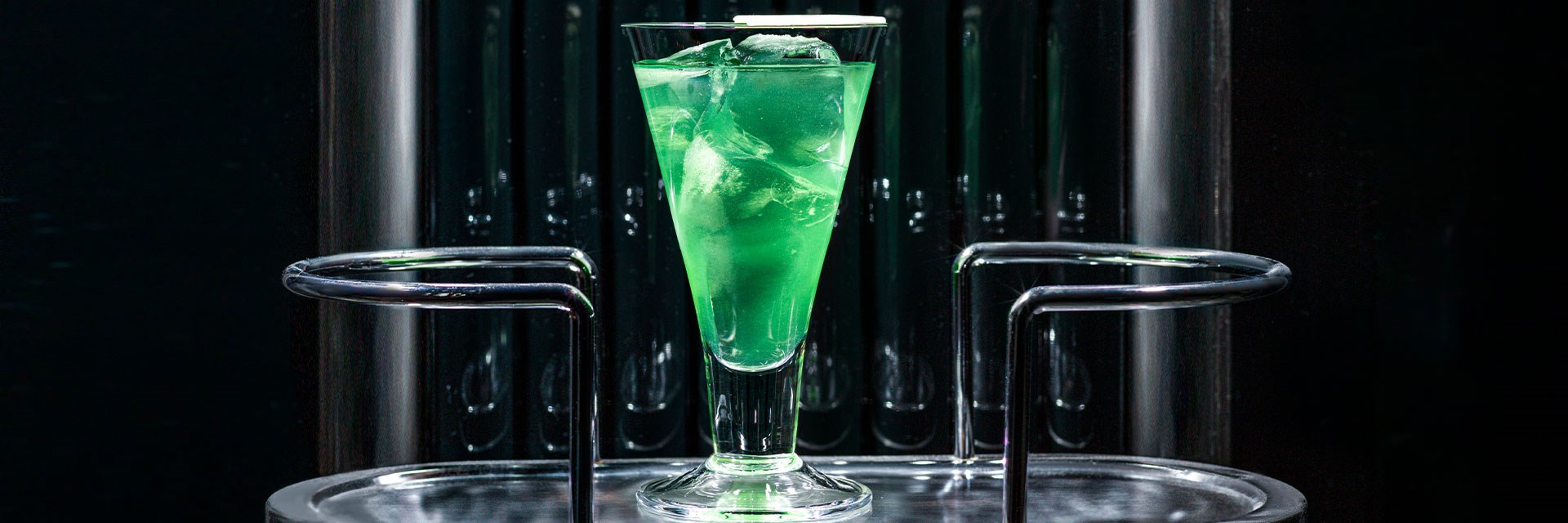 Green cocktail in a glass with ice