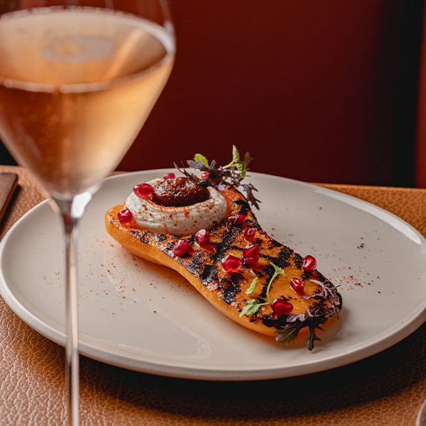 A meticulously arranged pecan tart with a glossy glaze, highlighting the rich, warm tones of the pecans against a wooden backdrop.