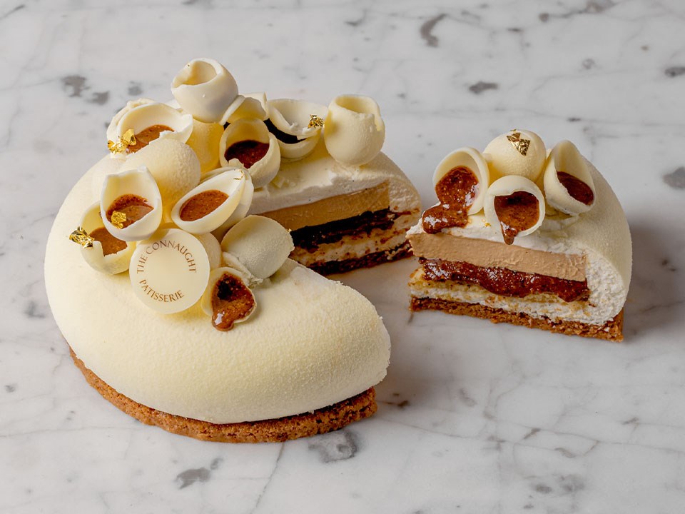 Easter Entremet This intricate dessert is made from white chocolate mousse, with layers of pecan crème brulé, pecan praline, and almond sponge with crunchy almond, and is topped with white chocolate eggs.