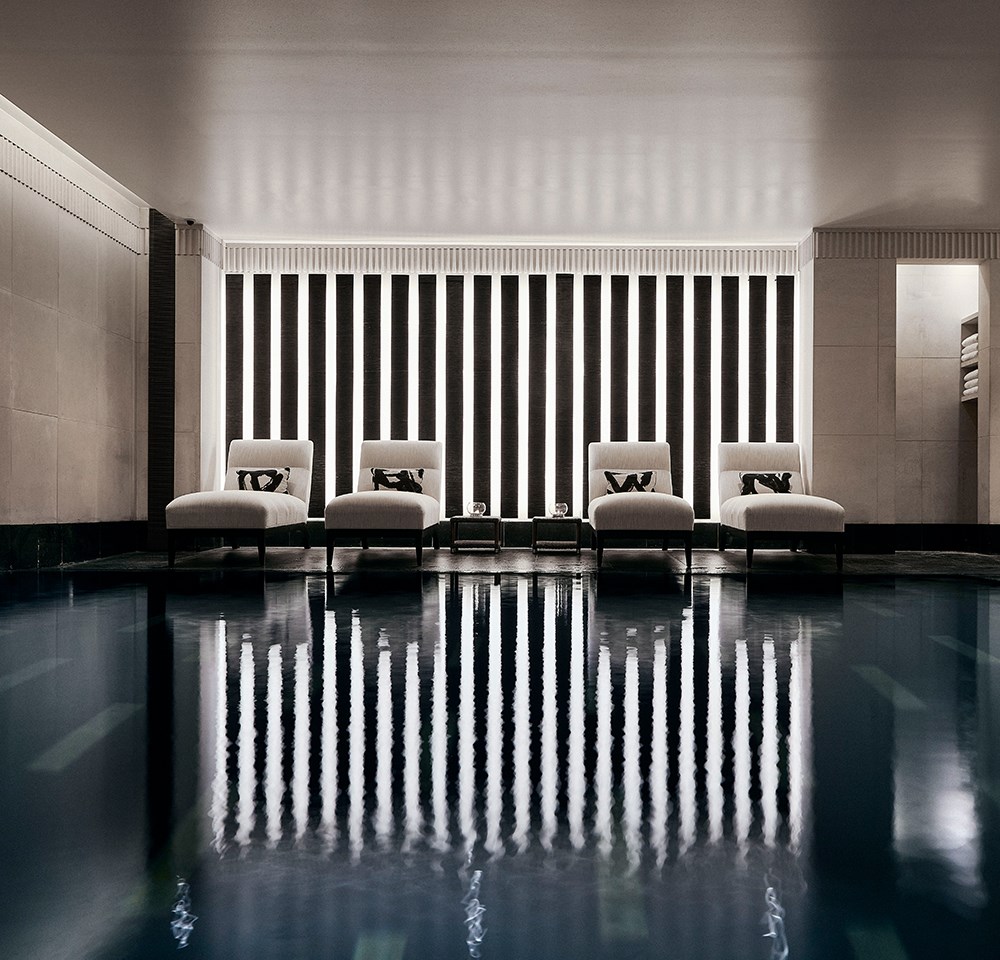 Four comfortable recliners, next to the black granite swimming pool in Aman Spa.