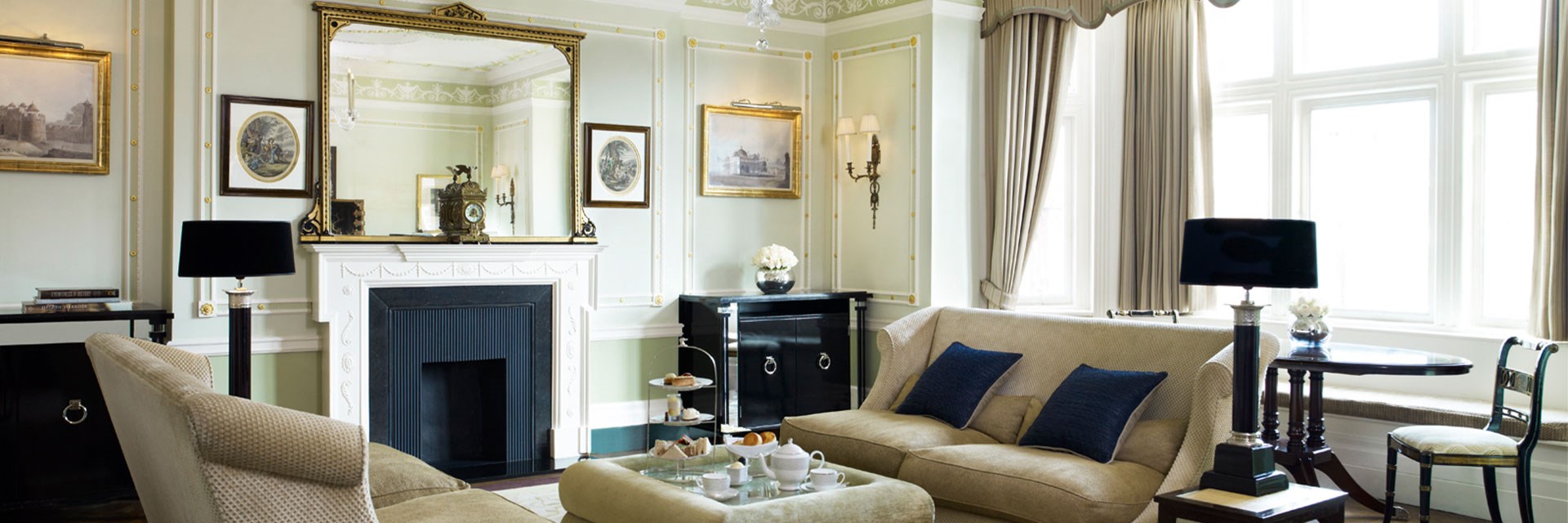 afternoon tea on coffee table, two sofas, fireplace and mirror