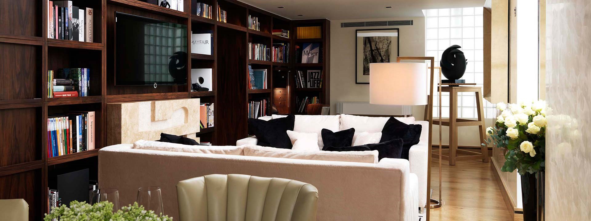 The Library Suite at The Connaught - Lounge view with couches and library with books and TV.