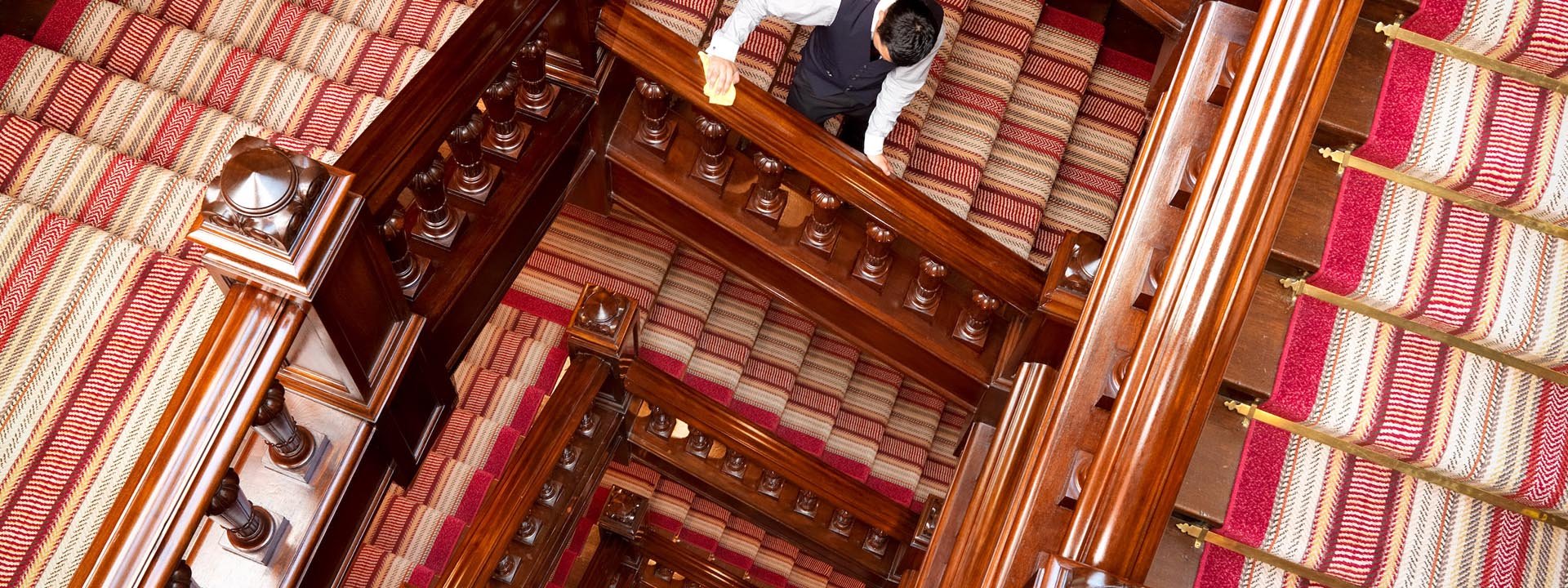 An aerial shot of the staircase showing the striped red, white and golden carpet.