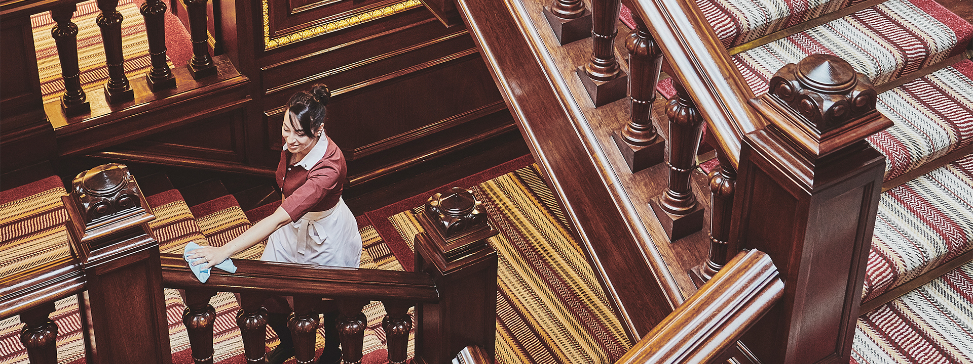 
A railing of a spiral staircase being cleaned by a team member.