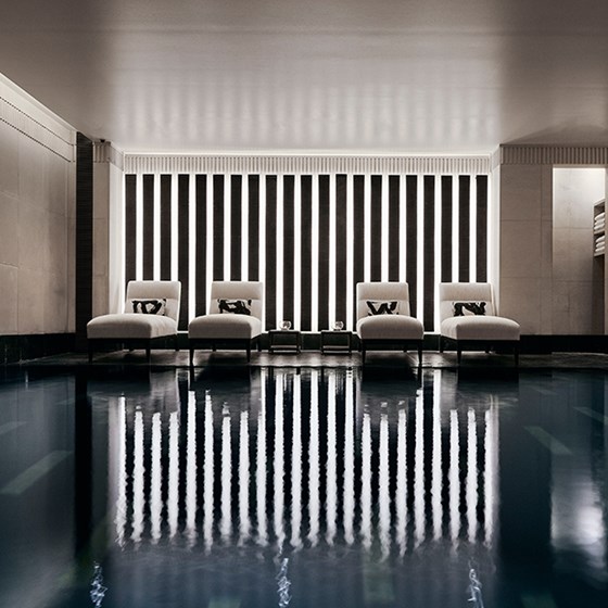 Four comfortable recliners, next to the black granite swimming pool in Aman Spa.