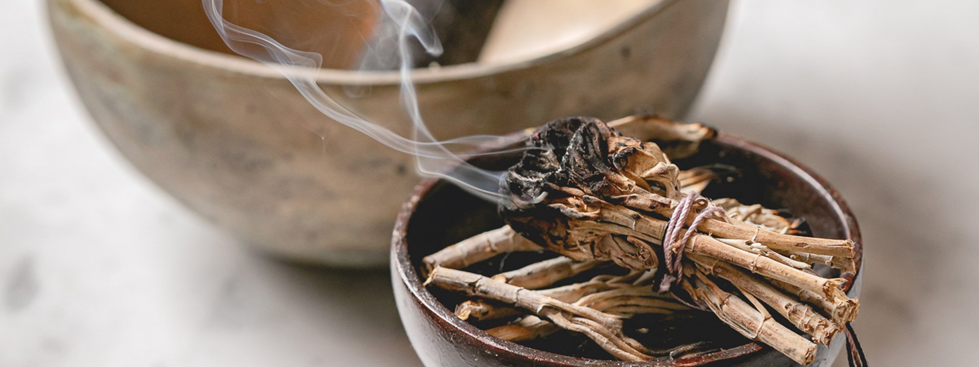 Small wooden sticks in a bowl emitting smoke at the Aman Spa.