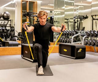 Focused man exercising with bands in The Connaught's spacious Aman Spa gym.