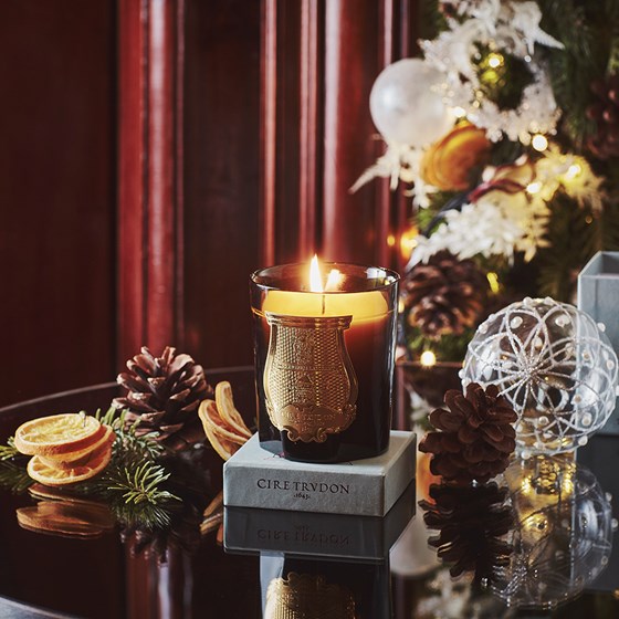 Photo of a candle and Christmas decorations, which can be found at The Connaught shop.