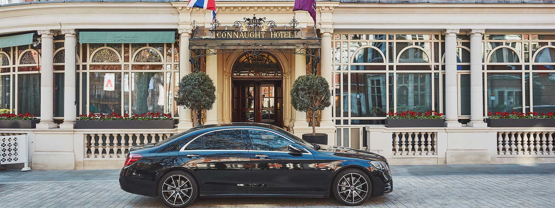 A black car near the entrance of The Connaught hotel.