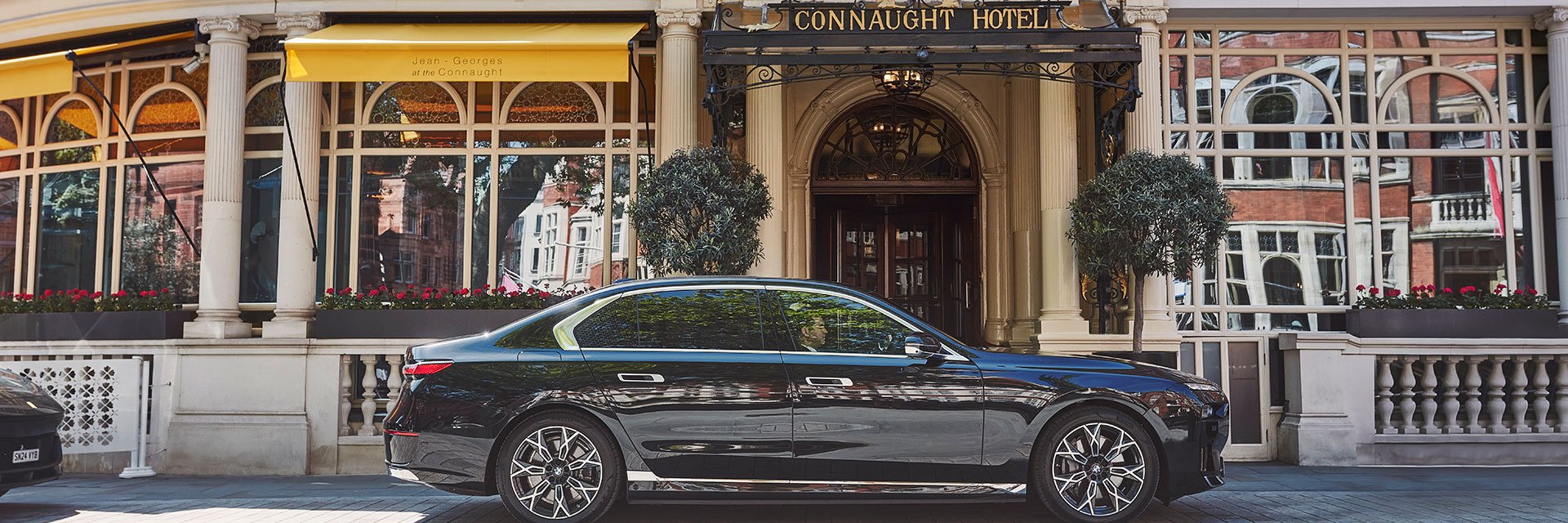 Exterior of The Connaught Hotel with one of the car fleets parked outside on a sunny day