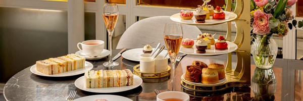 Elegant afternoon tea setting with finger sandwiches, patisserie, and champagne at The Connaught.