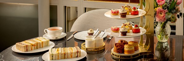 Full table view of The Connaught’s Spring Afternoon Tea, with floral backdrop and layered tea stand.