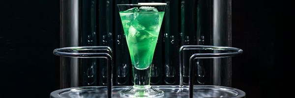 Green cocktail in a glass with ice