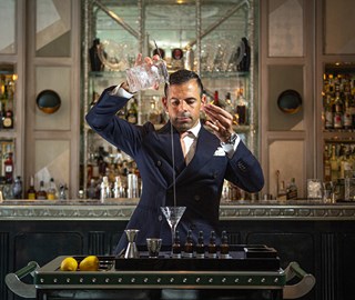 A focused mixologist in the process of making a delicious drink at The Connaught Bar.