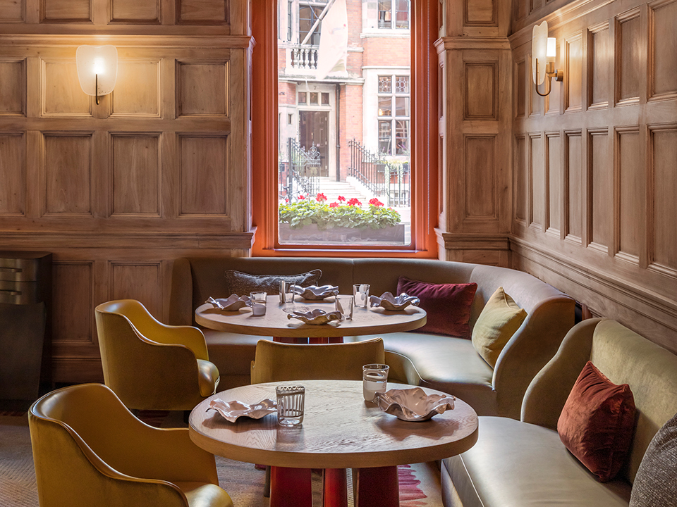 Dining room of Helene Darroze at The Connaught with pink and yellow chairs and a large window