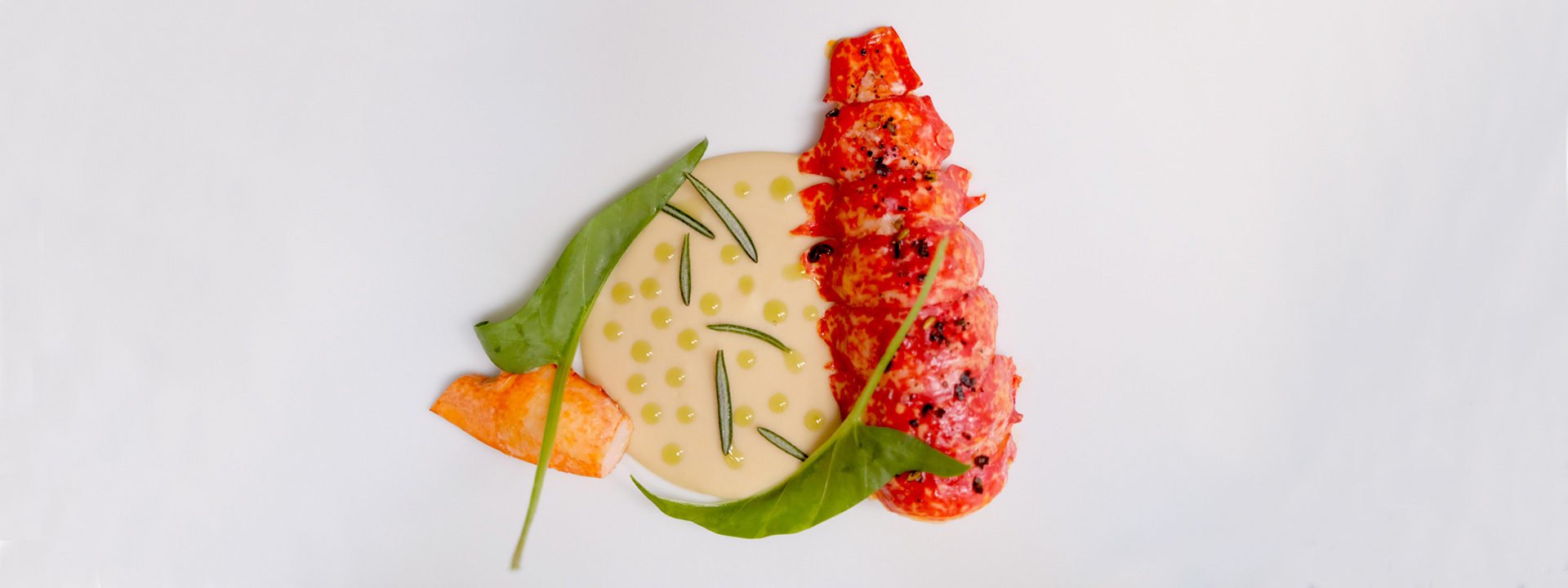 
Lobster in tiny pieces with a sauce of yellow tones presented in an exquisite way.