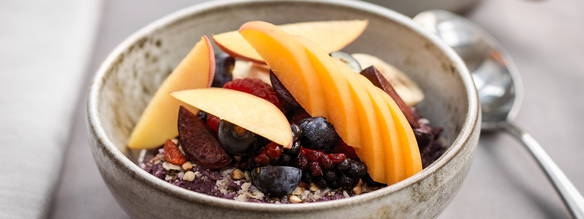 
A fruit bowl that includes apple and raspberry.