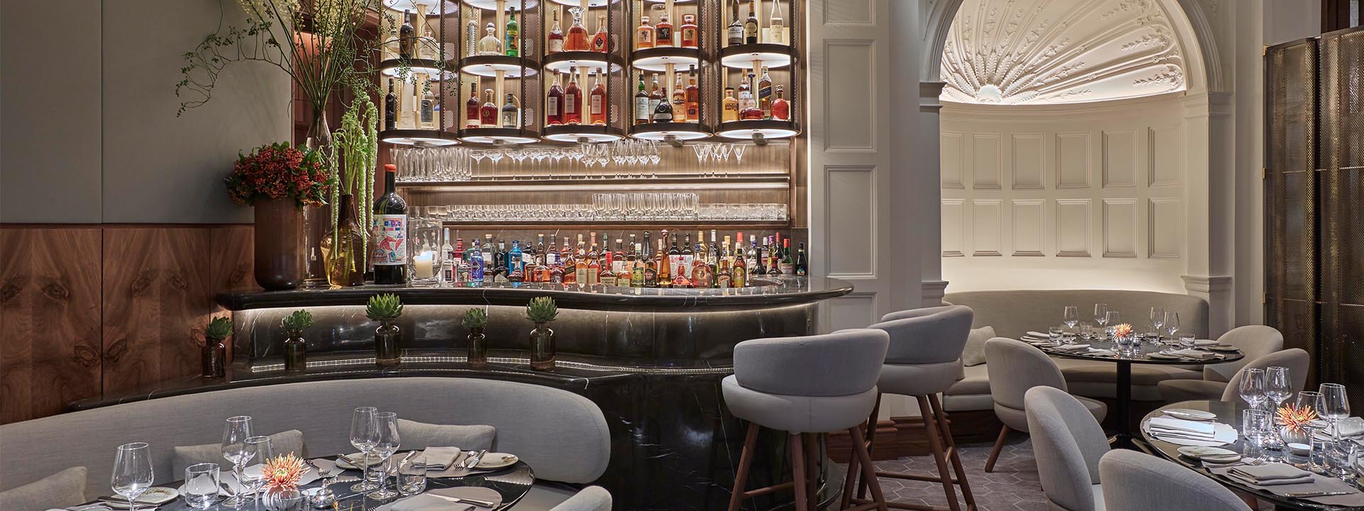 View of the space Jean-Georges at The Connaught, with a bar and sitting area for dining, in a modern interior.