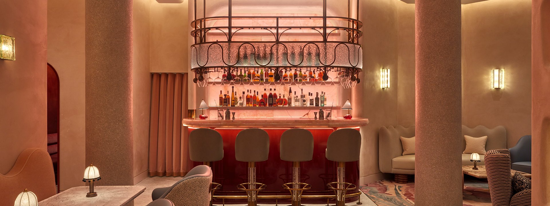 A red-lighted bar area and four bar stools in the red room.