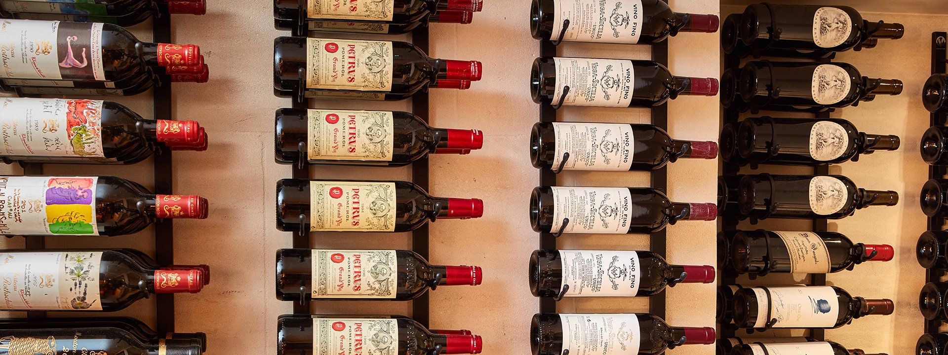 A collection of wines on the shelf from Petrus to Vega Sicilia wines, which can be ordered from The Sommelier's Table.