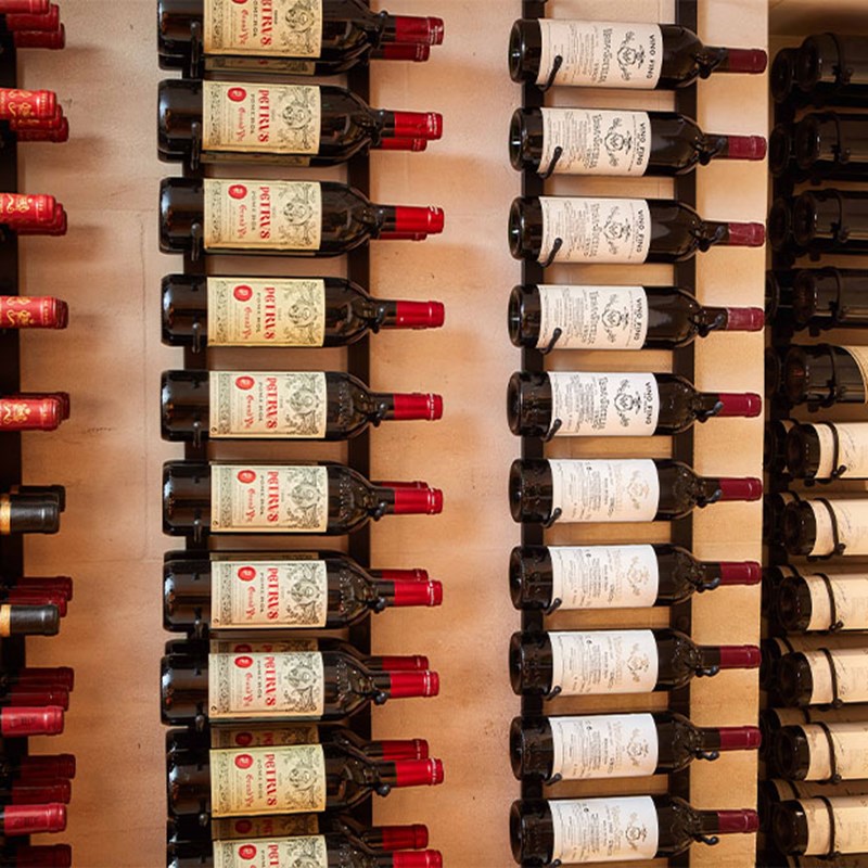 Rows of red wine hung on the wall, on their side.