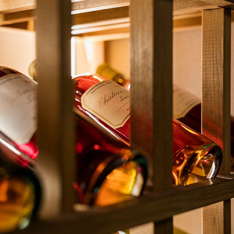 Side angle shot of bottle of sauterne in wine racks in the wine cellar