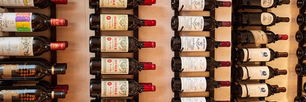 Rows of red wine hung on the wall, on their side.