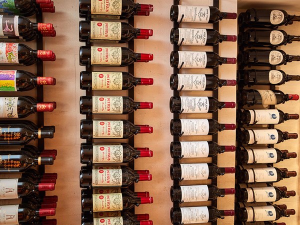 Rows of red wine hung on the wall, on their side.