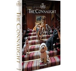 Cover of The Connaught book by Assouline, featuring a group of dogs sitting on the hotel’s grand staircase lined with a red patterned carpet.