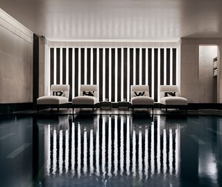 Four comfortable recliners, next to the black granite swimming pool in Aman Spa.