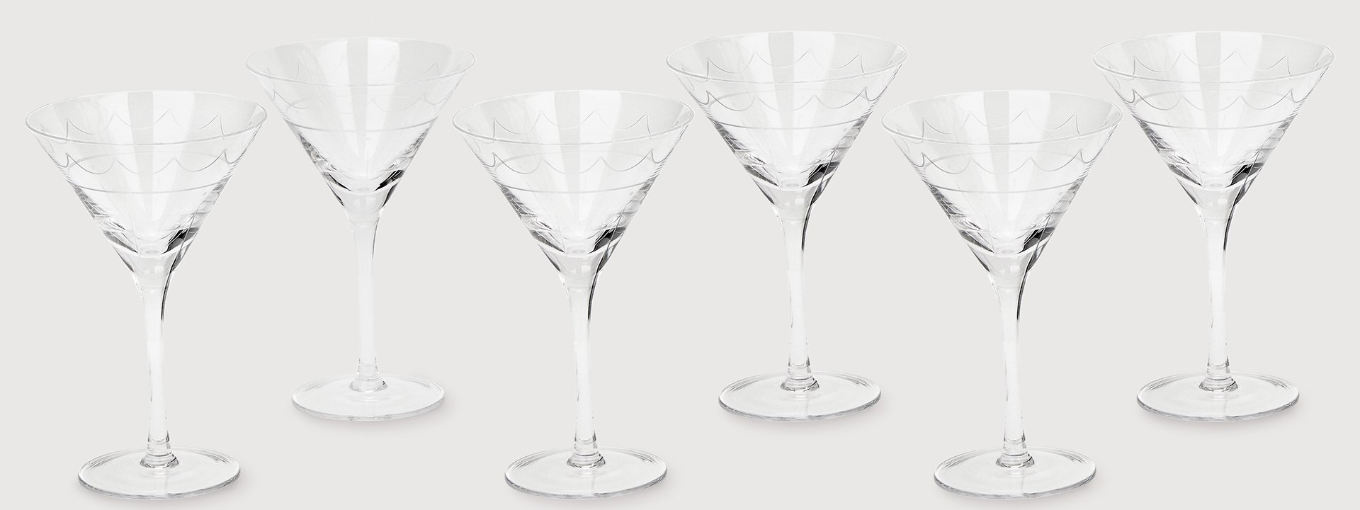 A group of six empty martini glasses.