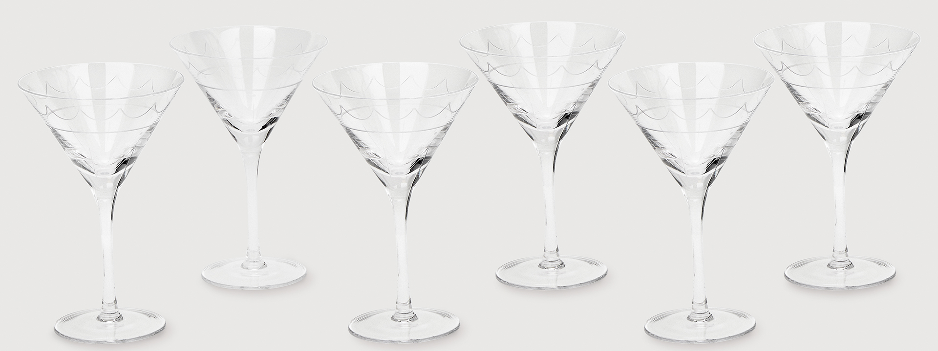 A group of six empty martini glasses.