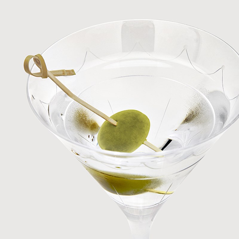 A martini glass with an olive inside, a drink that can be ordered at The Connaught Bar.