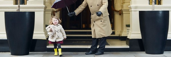Doorman holds child's umbrella over the little girl