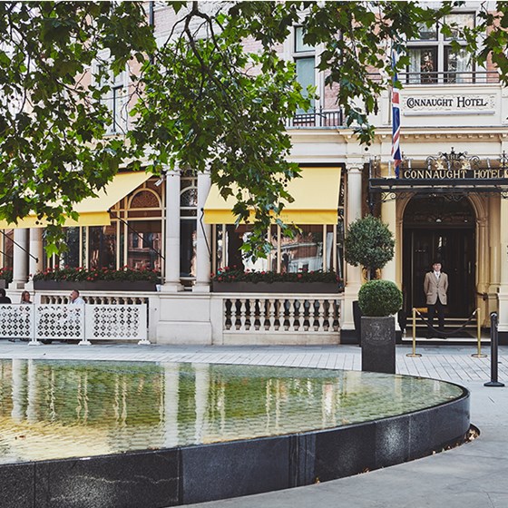 Exterior view outside the entrance of The Connaught hotel, with the concierge in front.