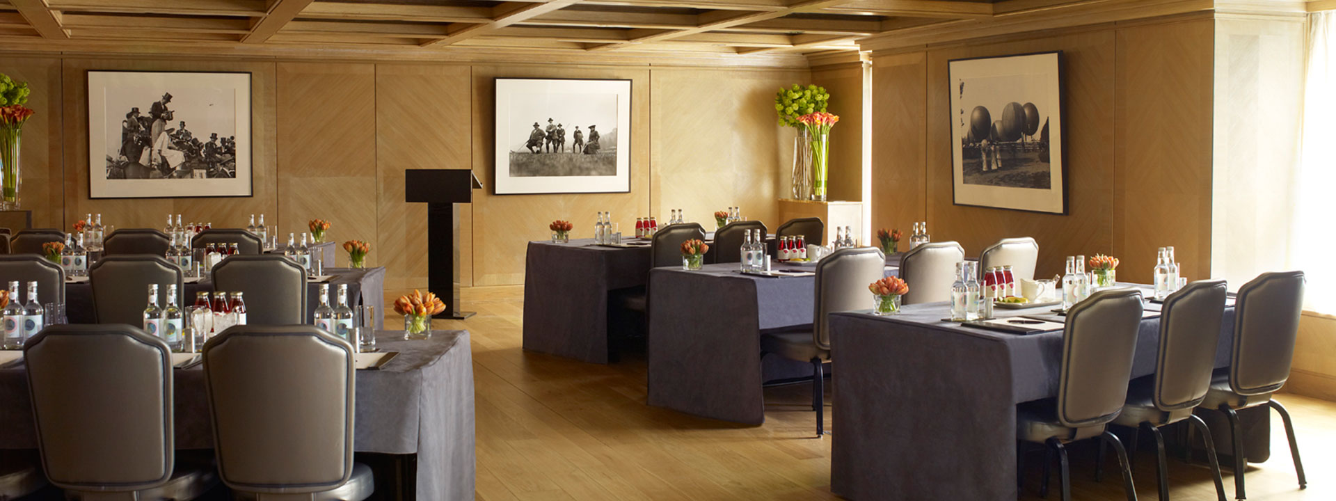 View of the set dining tables decorated with floral arrangements in the Maple Room at The Connaught.