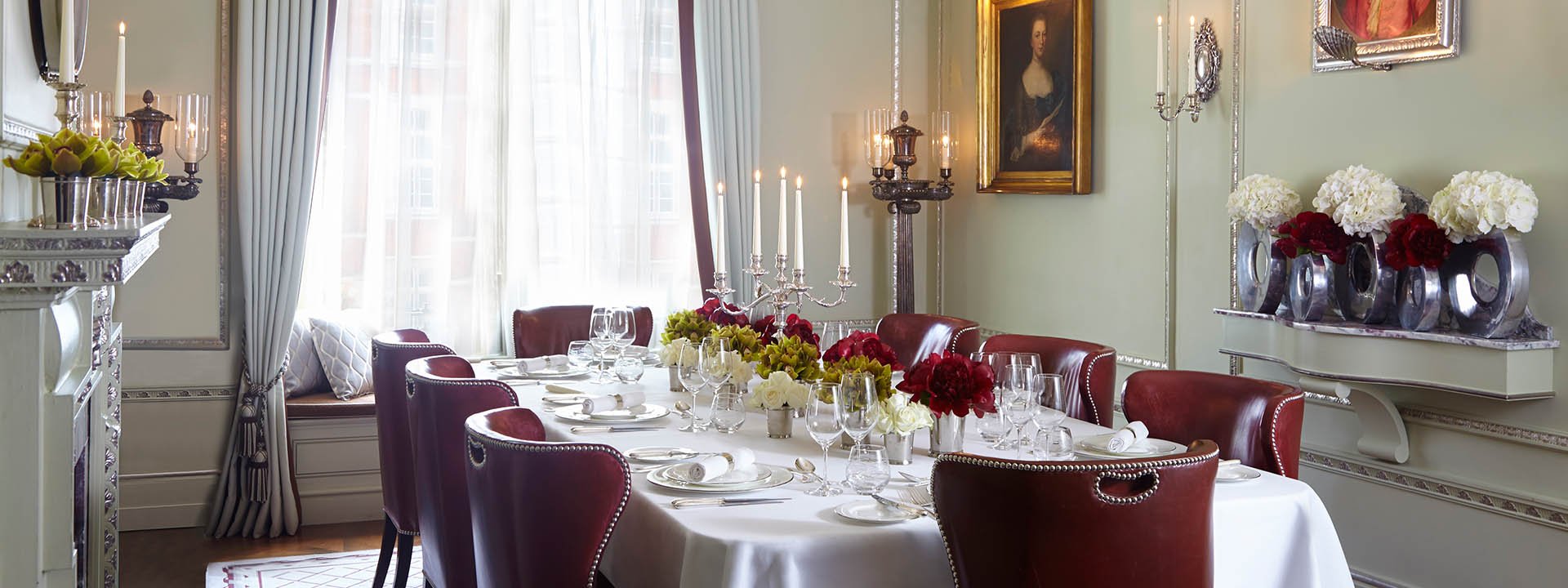 View of the dining table set in the Georgian Room at The Connaught, luxuriously decorated with floral arrangements.