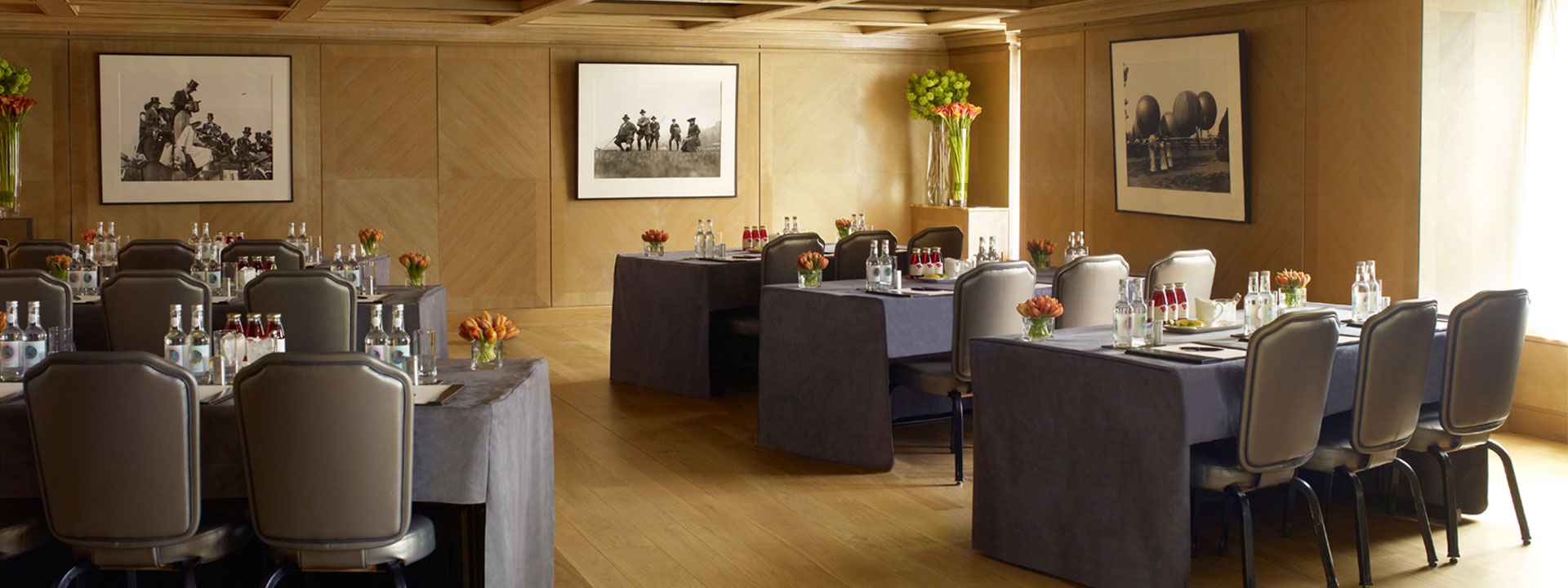 View of the set dining tables decorated with floral arrangements in the Maple Room at The Connaught.