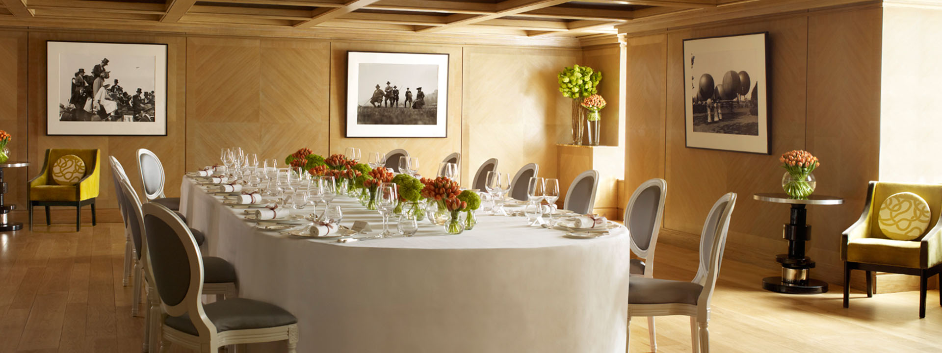 Elegant long white table with cutlery and glasses in daylight.