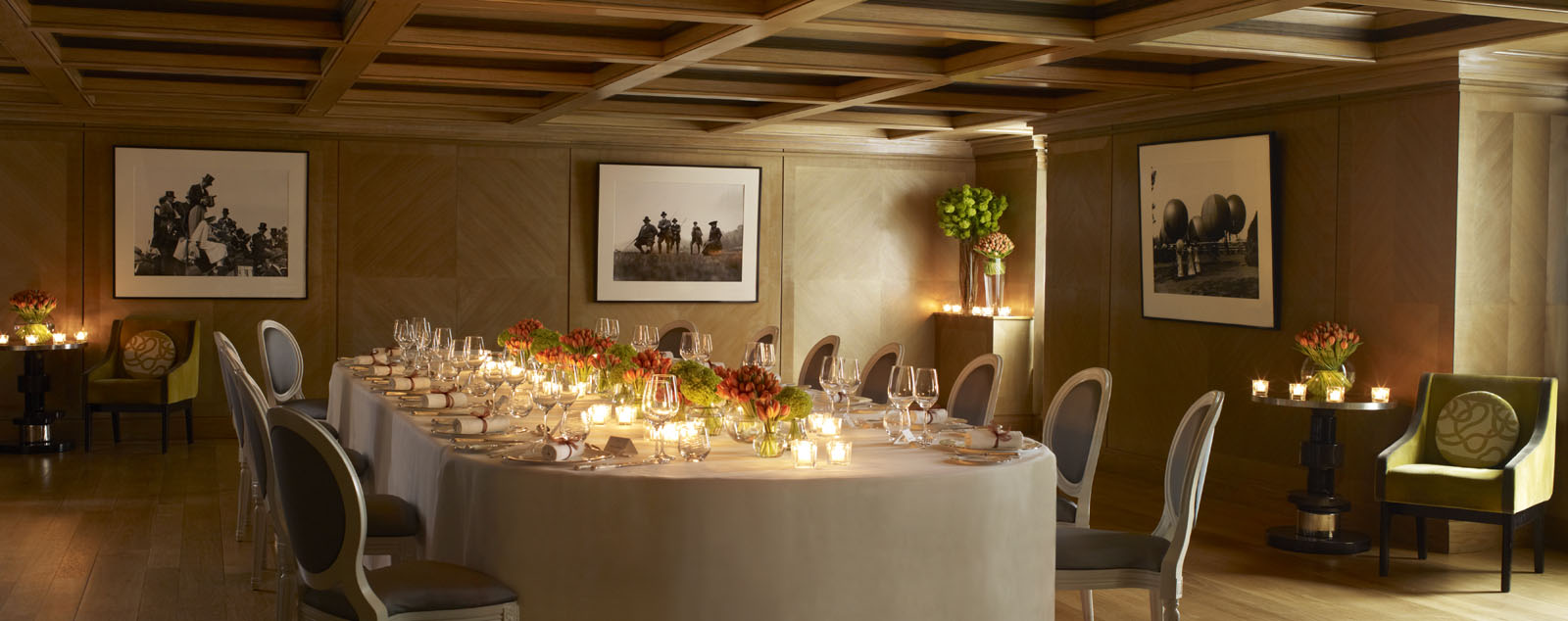 
Elegant long white table with cutlery and glasses and burning candles.