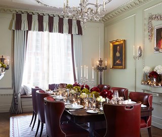 View of the dining table set in the Georgian Room at The Connaught, luxuriously decorated with floral arrangements.