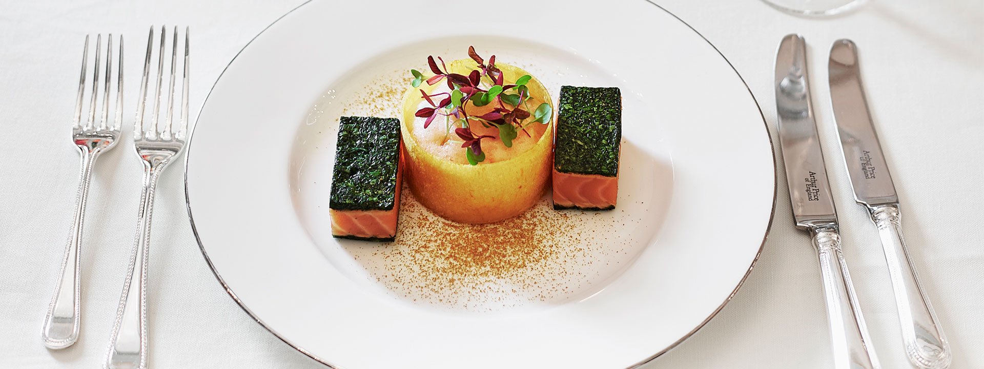 Presentation of delicious food on a white plate at The Connaught, creatively assembled and garnished.