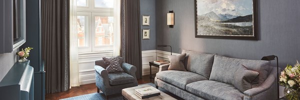 Coburg Suite: living area with sofa, coffee table, books, painting at the back of the room