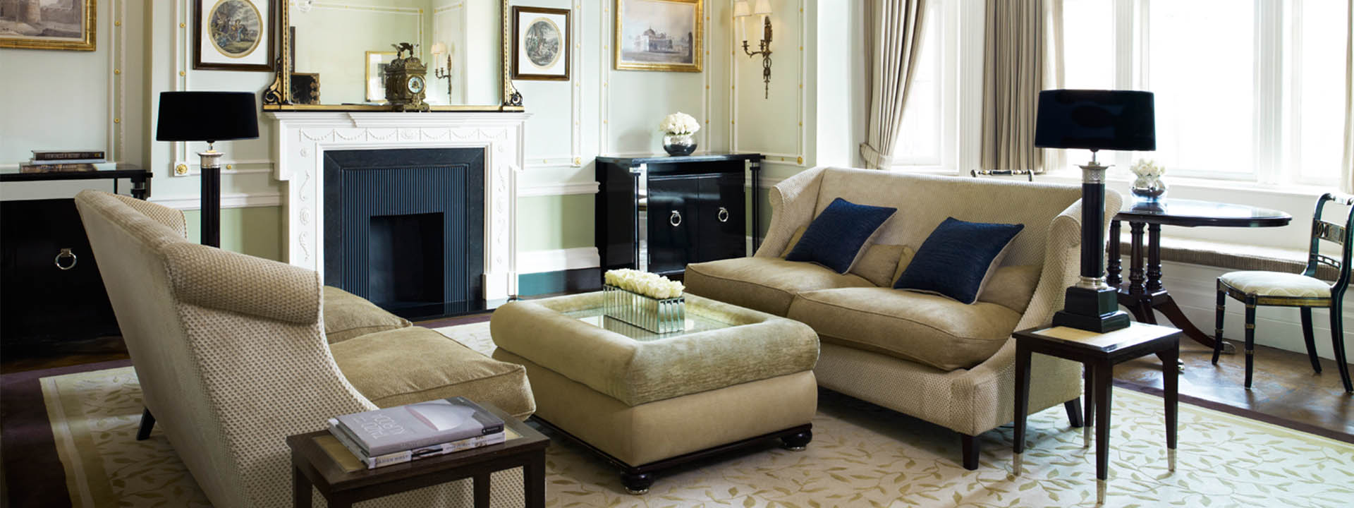 Living room in the luxurious interior of The Connaught suite, with comfortable beige sofas.