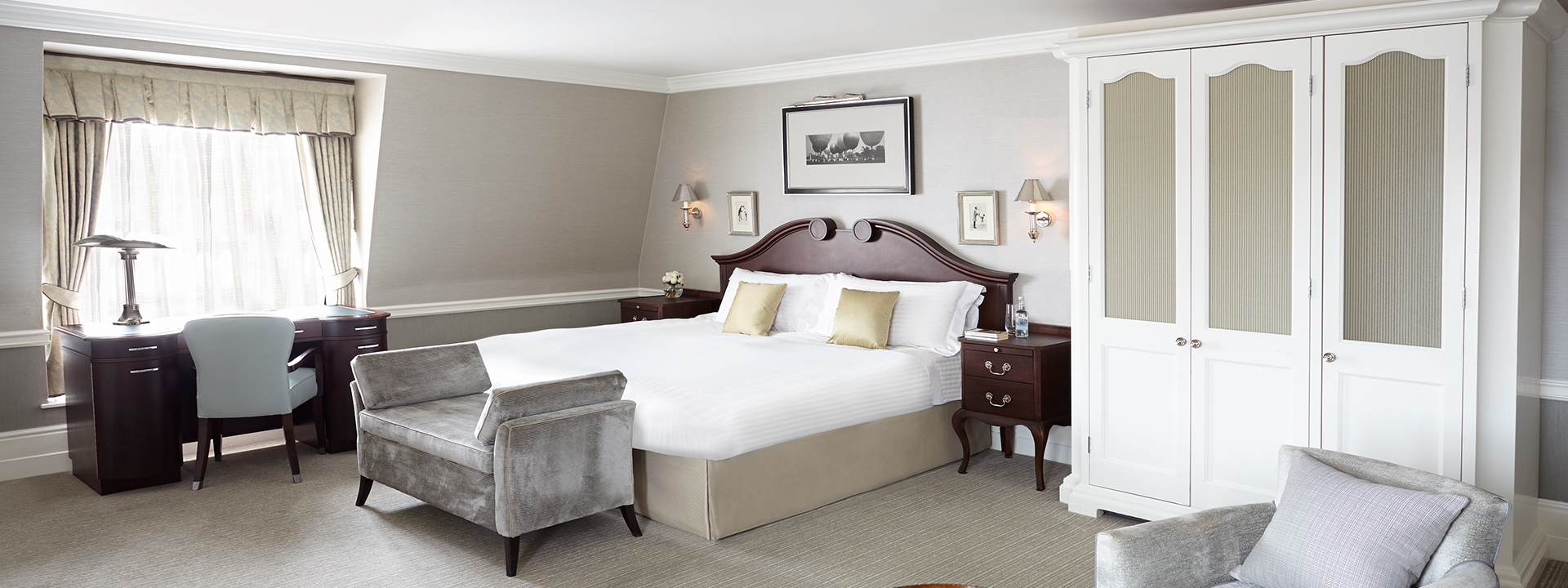Spacious white King Bed and large closet with a large window at deluxe Junior Suite.
