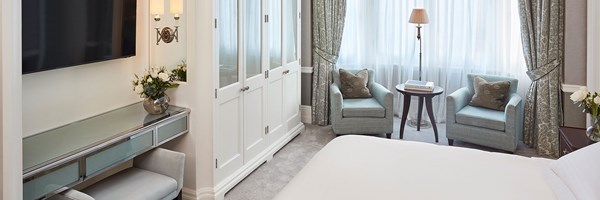 white wardrobe, two blue chairs with cushions