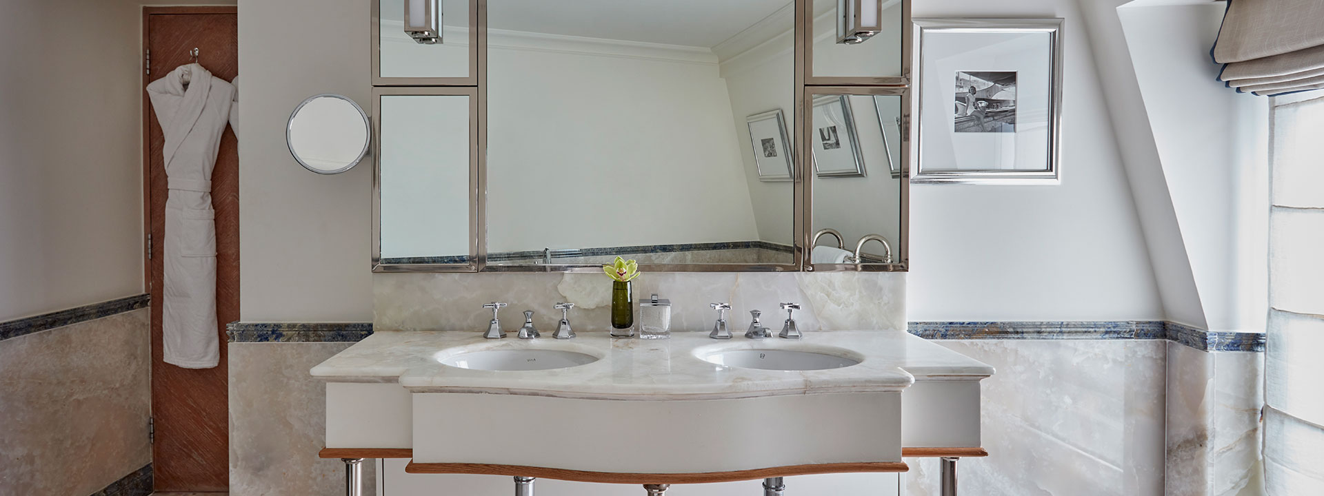 A view of the marble bathroom and a sink with large mirrors at The Eagles Lodge, in The Connaught.