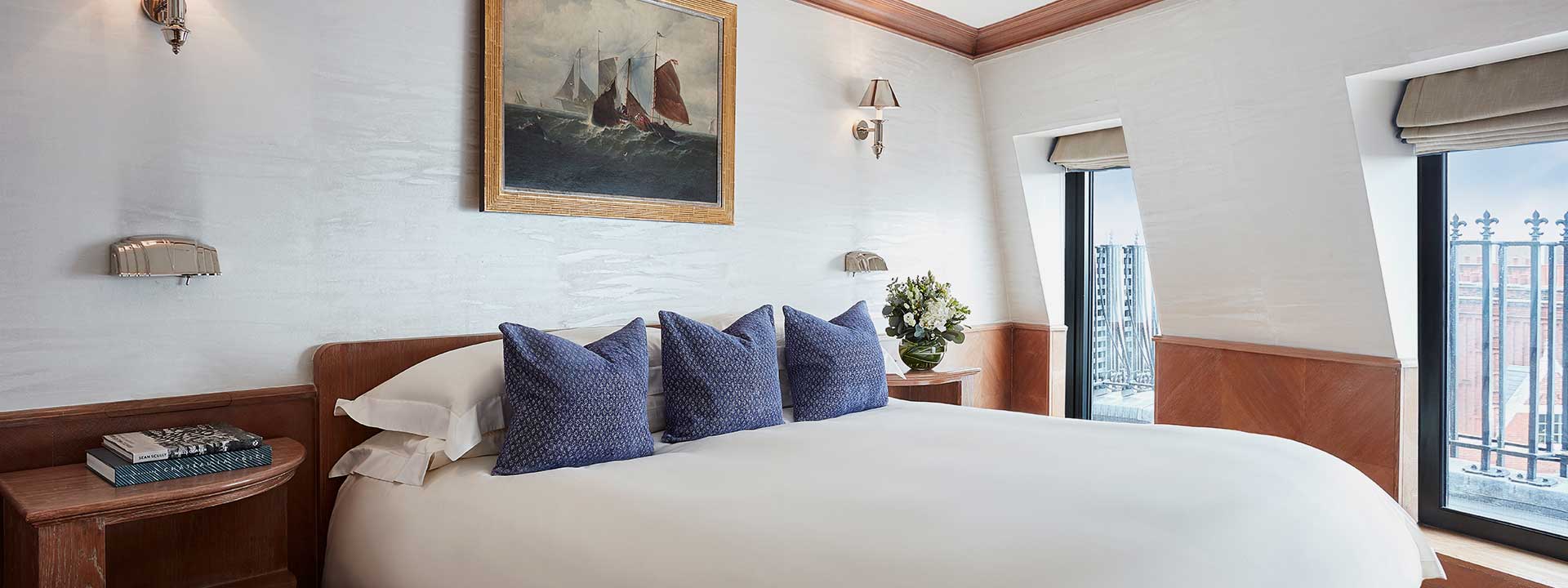 A view of a bedroom and King Bed in a nautical-style interior at The Eagles Lodge, The Connaught.