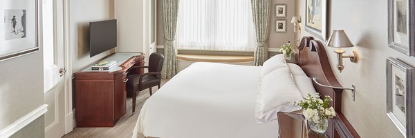 queen sized bed, two bed side tables with vases of flowers